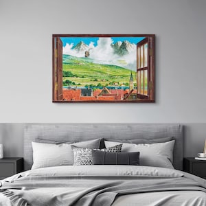 May include: A framed watercolor painting depicts a scenic view through an open window. The artwork showcases a vibrant landscape with green hills, snow-capped mountains, and a quaint village with red-tiled roofs. The window frame is a warm brown.