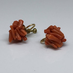 May include: A pair of gold tone clip-on earrings with coral clusters. The coral is a vibrant orange colour and the earrings are in good condition.
