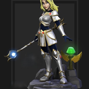 May include: A detailed figurine of a female character in silver and gold armour, holding a staff with a glowing blue orb. She has blonde hair and is standing on a stone base. A green gem is on a golden stand.