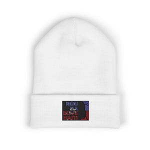 May include: White beanie with a rectangular patch featuring the text "NOU KA SOVE HAITI" and a silhouette of a person's profile. The patch has red, blue, and purple colors.