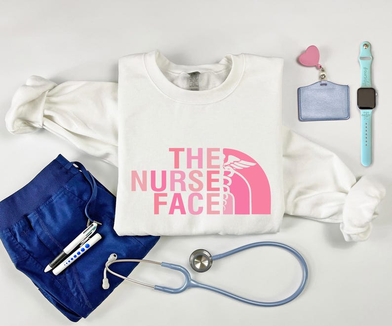 a white t-shirt with a pink logo, a stethoscope, a watch, a bracelet, and some other medical or nursing-related items.