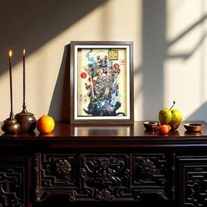 May include: A framed artwork depicting a deity figure, displayed on a dark wooden table. Two lit candles in ornate holders, an orange, and fruit are arranged on the table. The artwork features vibrant colors and intricate details.
