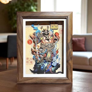May include: A framed artwork featuring a detailed, colorful illustration of a warrior figure. The artwork has a 3D effect, with layers creating depth. The frame is made of dark wood. The artwork includes Japanese text.