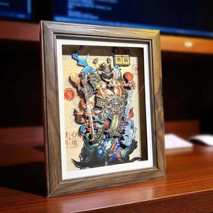 May include: Framed 3D paper art depicting a detailed, colorful Asian deity with a sword, set against a cream background. The artwork is in a wooden frame, with Chinese characters visible. The overall theme is cultural art.