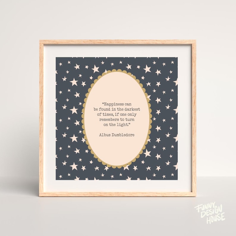 May include: A framed print with a light wood frame. The artwork features a dark blue background with white stars. An oval shape in the center contains a quote by Albus Dumbledore in black text. The quote reads: "Happiness can be found in the darkest of times, if one only remembers to turn on the light."