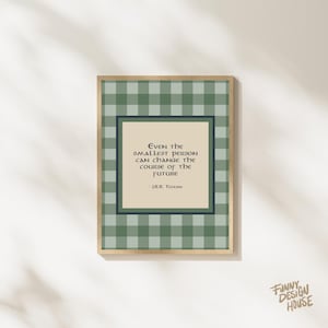 May include: A framed print featuring a quote by J.R.R. Tolkien: "Even the smallest person can change the course of the future." The print has a green and white check border and a beige background.