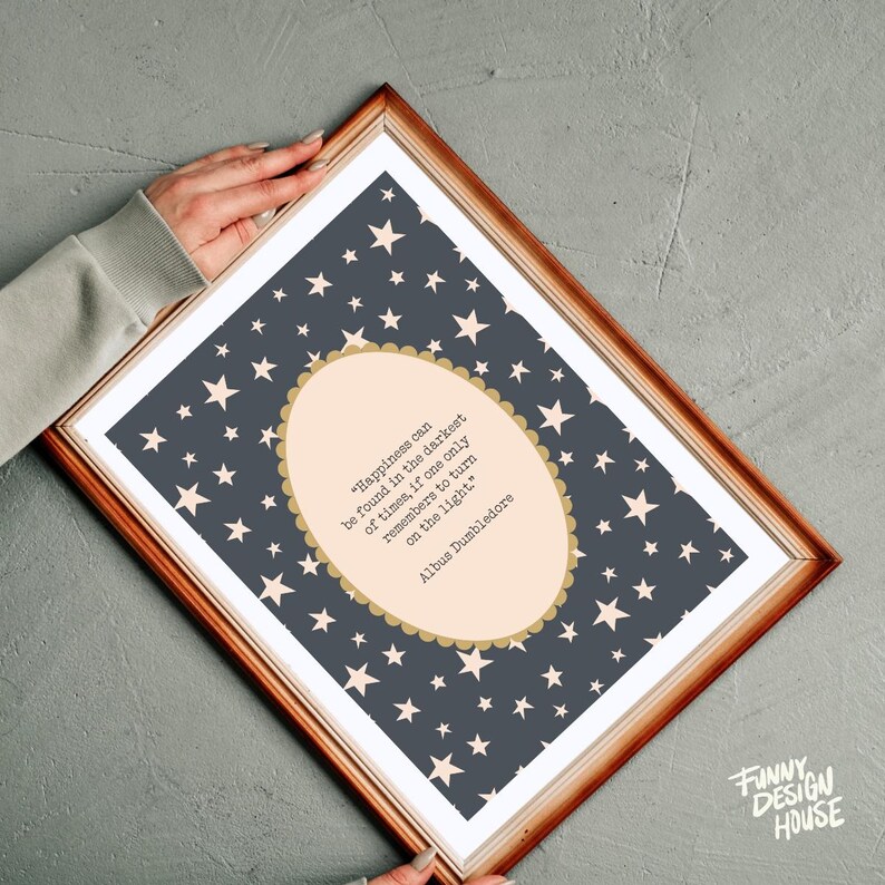 May include: A framed print featuring a quote by Albus Dumbledore, "Happiness can be found in the darkest of times, if one only remembers to turn on the light." The background is dark blue with white stars, and the quote is in a light peach oval.