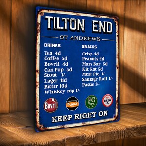 Peut inclure: Panneau métallique bleu d'aspect vieilli avec le texte "TILTON END" et une liste de boissons et de collations. Le panneau comprend des logos pour Bovril, Pukka, PG Tips Tea et Brew XI. Le panneau est affiché sur une étagère en bois.