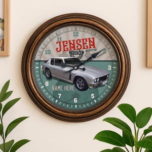 May include: Circular wall clock with a brown, distressed-look frame. The clock face displays a silver car graphic, the text "JENSEN LEGEND INTERCEPTOR", and the words "NAME HERE". The clock hands are black.