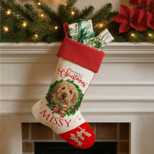 Könnte beinhalten: Ein Weihnachtsstrumpf mit roter Manschette und Spitze, gefüllt mit Geschenken. Der Strumpf zeigt ein Hundeporträt in einem Kranz, den Namen "Missy" und die Worte "Merry Christmas".