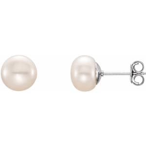 May include: A pair of pearl stud earrings. The pearls are round and white, with a subtle luster. The earring posts and backs are silver-colored metal. One earring is shown from the side, displaying the post and back.