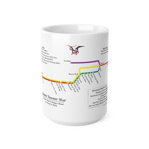 Puede incluir: Taza de cerámica blanca con un diseño de mapa colorido, que incluye varios lugares y el texto "HOBBIT TRANSIT MAP". También hay un gráfico de dragón rojo. La taza es de tamaño estándar.