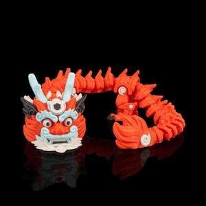 May include: A vibrant orange dragon figurine with intricate details. The dragon features a detailed head with blue and white accents, and a segmented body. The figurine is set against a black background, highlighting its bright colors and design.