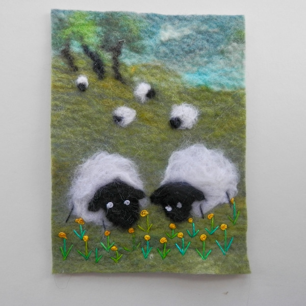 Imagen de fieltro o pared textil colgando de ovejas de fieltro con aguja. Decoración perfecta para el vivero