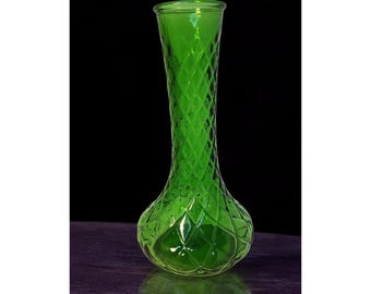 May include: A vibrant green glass vase with a diamond pattern. The vase has a bulbous base that tapers to a slender neck and a flared rim. The vase is approximately 10 inches tall.