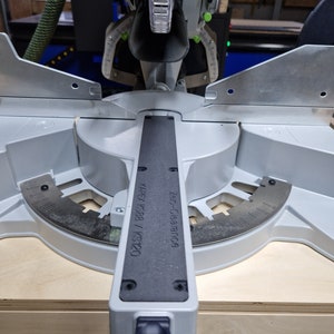 May include: A close-up of a silver miter saw with a black label that reads "KAPEX KS388 / KS120" and "Z-Saw Clearance 0.6".