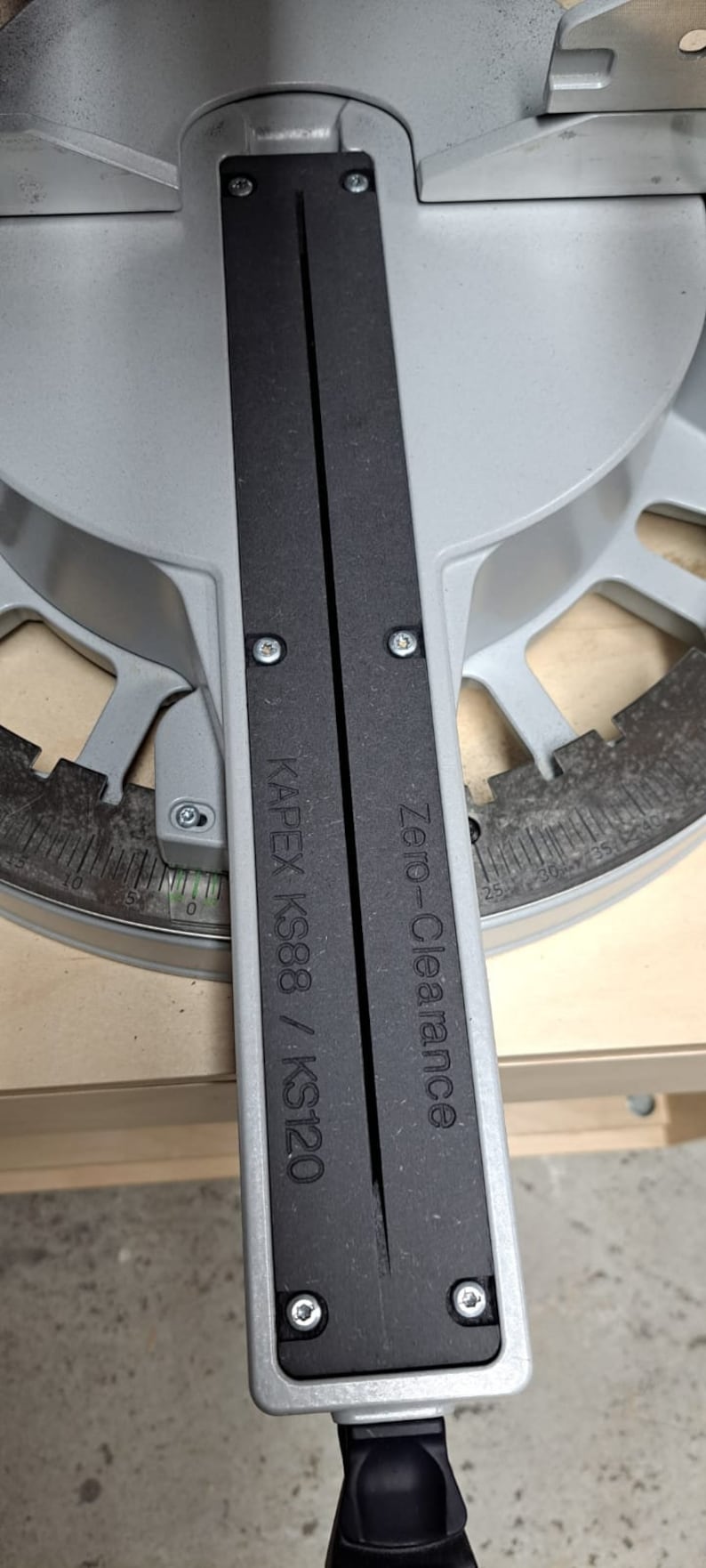 May include: Close-up of a silver and black saw with the text "Zero-Clearance" and "KAPEX KS88 / KS120" printed on it.