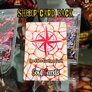 K&ouml;nnte beinhalten: Eine rechteckige Sammelkarte mit wei&szlig;em Hintergrund, einer roten Kompassrose und einem orange-roten netzartigen Muster. Der Text lautet One Piece Custom Card und Soul Cards in einer schwarzen Schriftart mit orangefarbenen Umrandungen.