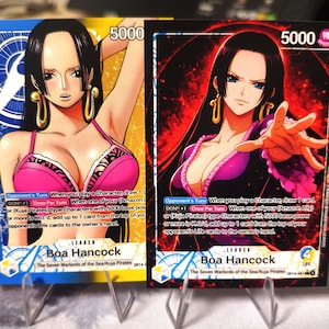 Può includere: Due carte collezionabili con Boa Hancock da "The Seven Warlords of the Sea/Kuja Pirates". Le carte mostrano una donna con lunghi capelli neri, che indossa un abito rosa e viola. Ogni carta ha il numero "5000" in alto.