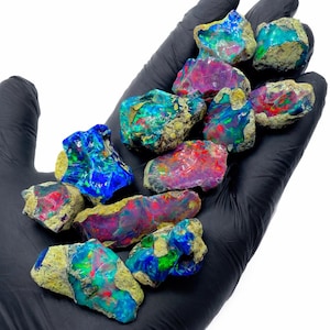 May include: A white ceramic mug with a black handle and the text "But First, Coffee" in a black, handwritten-style font. The mug is on a white surface.