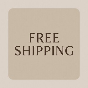 May include: A square, beige graphic with rounded corners features the words "FREE SHIPPING" in a dark brown, serif font. The text is centered on the graphic, which is set against a lighter beige background.