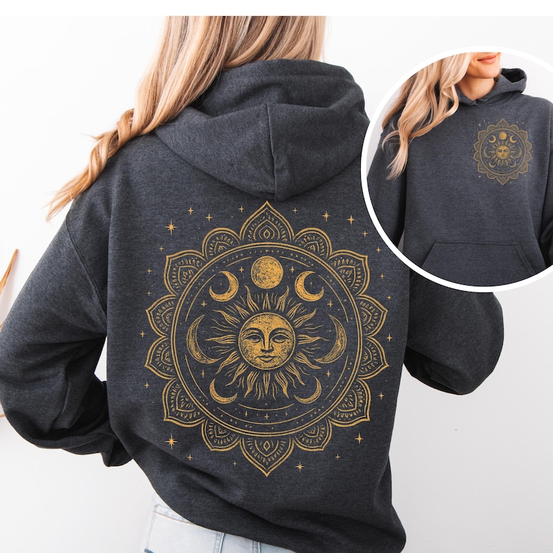 Puede incluir: Sudadera con capucha gris oscuro con un dise&ntilde;o de mandala dorado de sol y luna en la espalda. El dise&ntilde;o incluye un sol sonriente, lunas crecientes y estrellas. Una versi&oacute;n m&aacute;s peque&ntilde;a del dise&ntilde;o est&aacute; en la parte delantera.