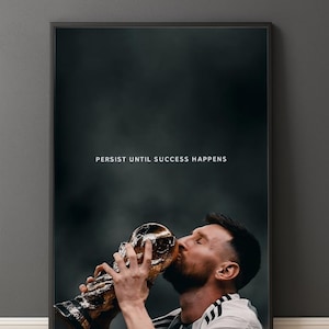 May include: Framed print showing a soccer player kissing a gold trophy. The image has a dark background with the text "PERSIST UNTIL SUCCESS HAPPENS" in white. The player is wearing a white and black jersey.