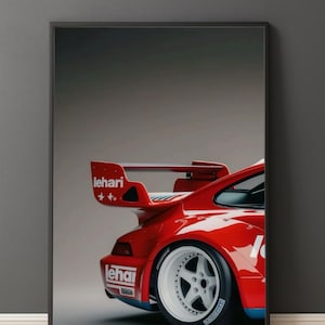 Peut inclure: Impression encadrée d'une voiture de sport rouge, avec un aileron arrière proéminent et des roues blanches. Le mot "lehari" est visible sur l'aile et le côté. Fond gris.