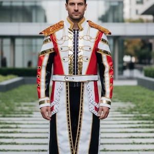 Puede incluir: Un abrigo de estilo militar con un diseño llamativo. El abrigo presenta una combinación de paneles rojos, blancos y negros, acentuados con adornos dorados y charreteras. El abrigo tiene un cuello alto y una cintura con cinturón, creando un look formal.