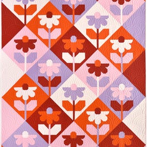 May include: A quilted blanket with a repeating floral pattern. The design features stylized flowers in white, pink, orange, and burgundy, set against a background of pink, lavender, and burgundy diamond shapes. The quilt is machine-stitched with a curved pattern.