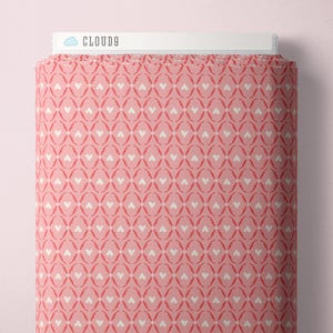 May include: A roll of pink fabric with a repeating pattern of white hearts and red oval shapes. The fabric is labeled "CLOUD9" in white text on a white background.