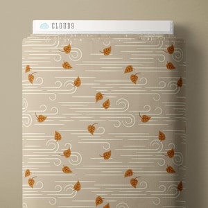 May include: A bolt of fabric featuring a light tan background with a repeating pattern of white horizontal wind lines and small orange autumn leaves. The top edge of the fabric bolt displays a white label with the text CLOUD9 and a cloud icon.