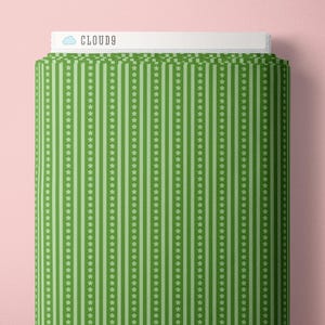 May include: A bolt of green fabric featuring a repeating pattern of vertical stripes in alternating shades of light and dark green, accented by thin white vertical lines of small flower icons. The top label displays the text CLOUD9.