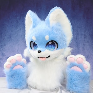 May include: A light blue and white furry fox head and paws costume. The fox head has large, expressive eyes with blue and white details, and a pink tongue. The paws are light blue with pink paw pads.