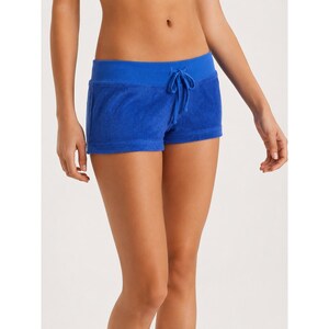 Puede incluir: Pantalones cortos de tela de rizo en color azul brillante con una cintura elástica ancha y un cordón ajustable a juego. Los pantalones tienen un corte corto y ajustado con un acabado de tela suave y texturizada, de diseño sencillo.