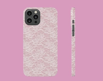 May include: A phone case with a delicate, white floral lace pattern over a light pink background. The case is shown from the front and side, showcasing the design and the camera lens cutout.