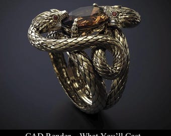 May include: A gold-colored ring featuring two detailed snake designs coiled around a large, brown gemstone. The snakes' heads are positioned on either side of the gem, with red accents for the eyes. The ring has a textured, scale-like pattern. Text at the bottom reads "CAD Render - What You'll Cast."