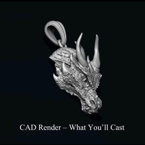 Peut inclure: Un pendentif en niveaux de gris en forme de tête de dragon, avec des écailles détaillées, des cornes et une boucle pour une chaîne. Le texte "CAD Render - What You'll Cast" est en bas. Le pendentif est sur fond sombre.