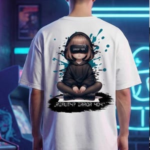 Könnte beinhalten: Weißes T-Shirt mit einem digitalen Kunstdesign auf der Rückseite. Das Design zeigt eine Kapuzenfigur mit VR-Brille, dem Text "REALITY? ERROR 404." und Spritzern in Türkis und Schwarz.