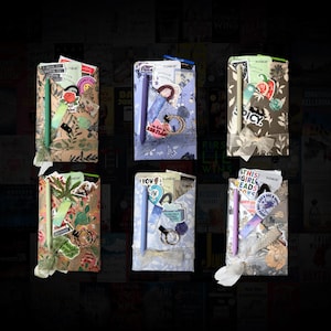 May include: Six gift sets, each wrapped in patterned paper and tied with ribbon. Each set includes a pen, stickers, and other small items. The sets have different colour schemes and patterns, with some featuring floral and botanical designs.