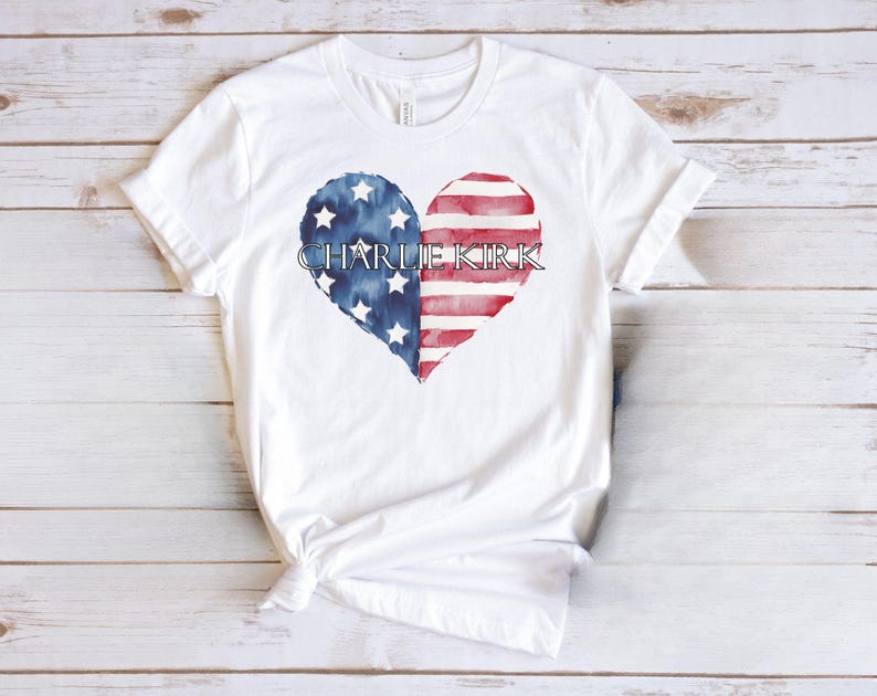 A white t-shirt with a heart-shaped design featuring the text "CHARLIE KIRK" and an American flag pattern.