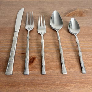 Puede incluir: Juego de tres tazas de cerámica con acabado mate moteado. Las tazas son de color crema, gris claro y gris oscuro. Cada taza tiene un diseño simple y minimalista.