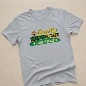 May include: A light gray t-shirt with the words "Quality Learning Center" in yellow and green, and the phone number "1-800-FRAUD". The shirt has short sleeves and a crew neck.