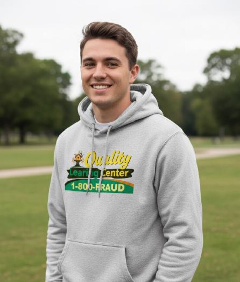 May include: A light gray hoodie with a front pocket and a drawstring hood. The hoodie features a graphic with the words "Quality Learning Center" and the phone number "1-800-FRAUD" in yellow, green, and black.