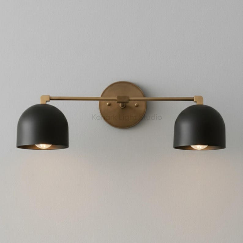 Modern brass wall sconce side view showing depth from wall, double light vanity fixture with glass shades, contemporary bathroom wall lighting