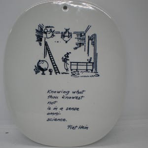 May include: White ceramic oval plate with a black and white illustration of a person on a ladder in a library. The plate has a quote by Piet Hein: "Knowing what thou knowest not is in a sense omniscience."