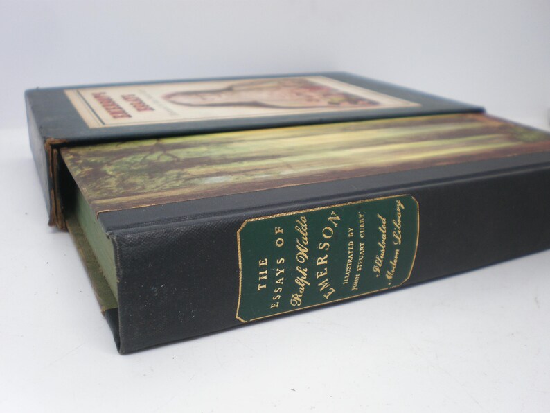 Pode incluir: Um livro preto de capa dura com letras douradas na lombada. O t&iacute;tulo &eacute; "The Essays of Ralph Waldo Emerson" com as palavras "Illustrated by John Stuart Curry" e "The Illustrated Library" abaixo do t&iacute;tulo.