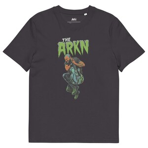 Può includere: T-shirt grigio scuro con la scritta verde "THE ARKN" e un'illustrazione di un musicista che suona la chitarra. L'illustrazione utilizza tonalità verdi, blu e marroni.