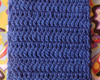 May include: A close-up of a blue crocheted scarf. The scarf is made with a simple stitch and has a textured look.