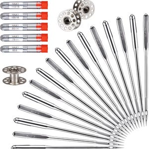 May include: A collection of sewing machine needles, bobbins, and needle cases. The needles are silver with the text "Ohl" printed on them. The needle cases are clear with orange caps. The bobbins are silver.